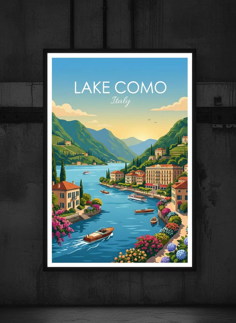 May include: A framed art print of Lake Como, Italy. The image shows a blue lake with boats, surrounded by green hills and buildings. The sky is blue and yellow. The text "Lake Como Italy" is at the top of the print. The artwork is set in a black frame.