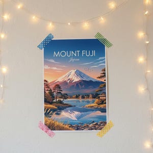 May include: A poster of Mount Fuji, Japan, is taped to a white wall with decorative string lights. The artwork depicts the mountain at sunset, with a lake and trees in the foreground. The text "MOUNT FUJI Japan" is at the top.