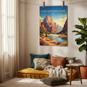 May include: A rectangular wall poster featuring a colorful illustration of Zion National Park, Utah, with towering red rock cliffs, a winding blue river, and desert vegetation under a clear sky, hanging from a string with wooden clips.