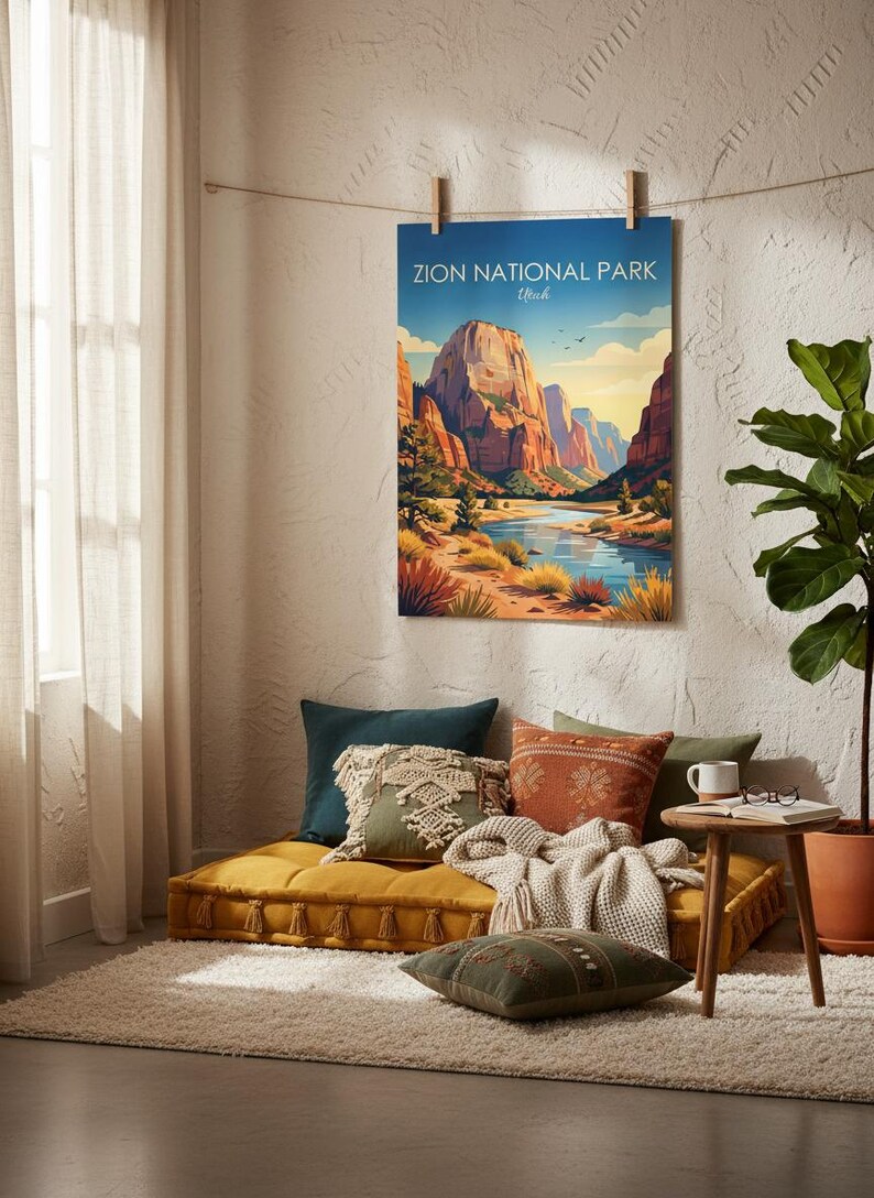 May include: A rectangular wall poster featuring a colorful illustration of Zion National Park, Utah, with towering red rock cliffs, a winding blue river, and desert vegetation under a clear sky, hanging from a string with wooden clips.