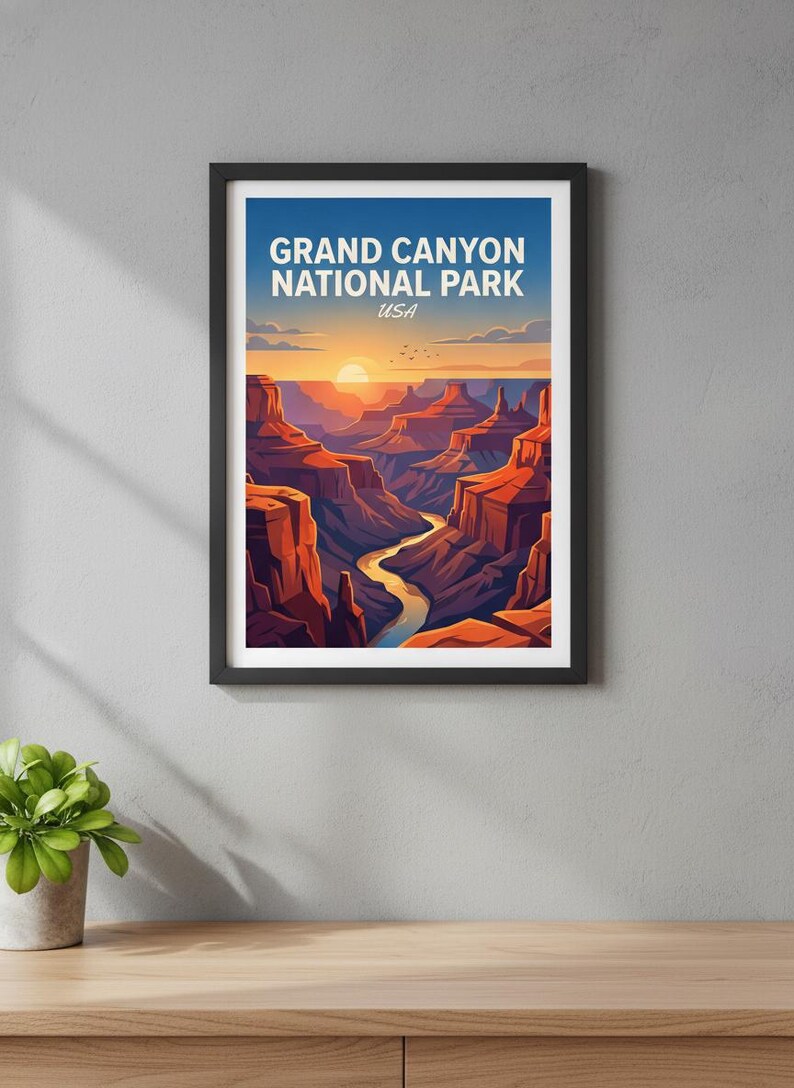 May include: Framed art print featuring a stylized illustration of the Grand Canyon at sunset. The artwork displays the canyon's layered rock formations, a winding river, and the text "GRAND CANYON NATIONAL PARK USA" in white against a blue sky.