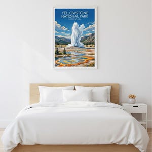 Pode incluir: Uma impress&atilde;o emoldurada do Parque Nacional de Yellowstone, Wyoming, com um g&ecirc;iser em erup&ccedil;&atilde;o com um cen&aacute;rio de montanhas e uma paisagem colorida. A impress&atilde;o &eacute; exibida acima de uma cama com roupa de cama branca.