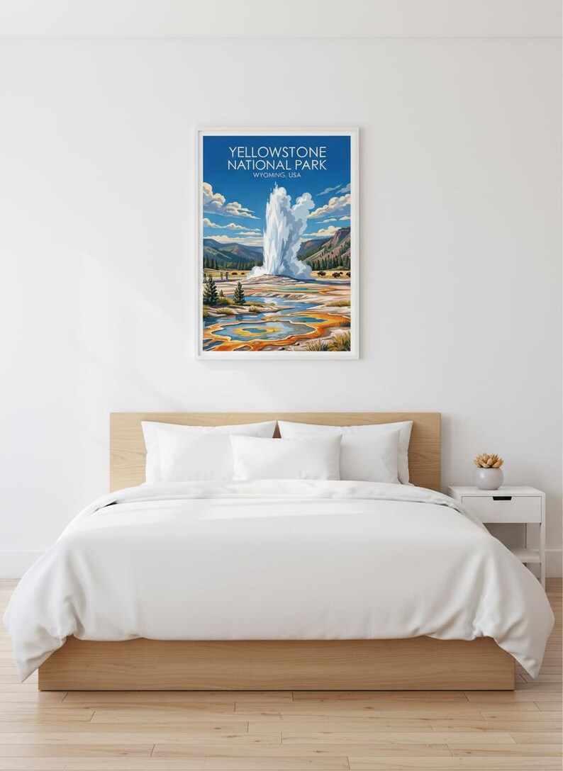 Pode incluir: Uma impress&atilde;o emoldurada do Parque Nacional de Yellowstone, Wyoming, com um g&ecirc;iser em erup&ccedil;&atilde;o com um cen&aacute;rio de montanhas e uma paisagem colorida. A impress&atilde;o &eacute; exibida acima de uma cama com roupa de cama branca.