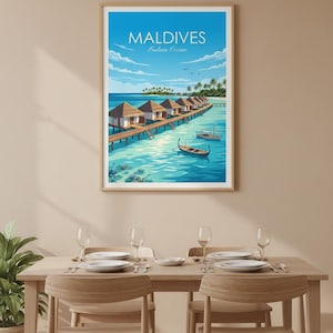 May include: A framed print of the Maldives, featuring overwater bungalows on a pier, turquoise water, and the text "Maldives Indian Ocean." The artwork is displayed above a dining table with place settings.