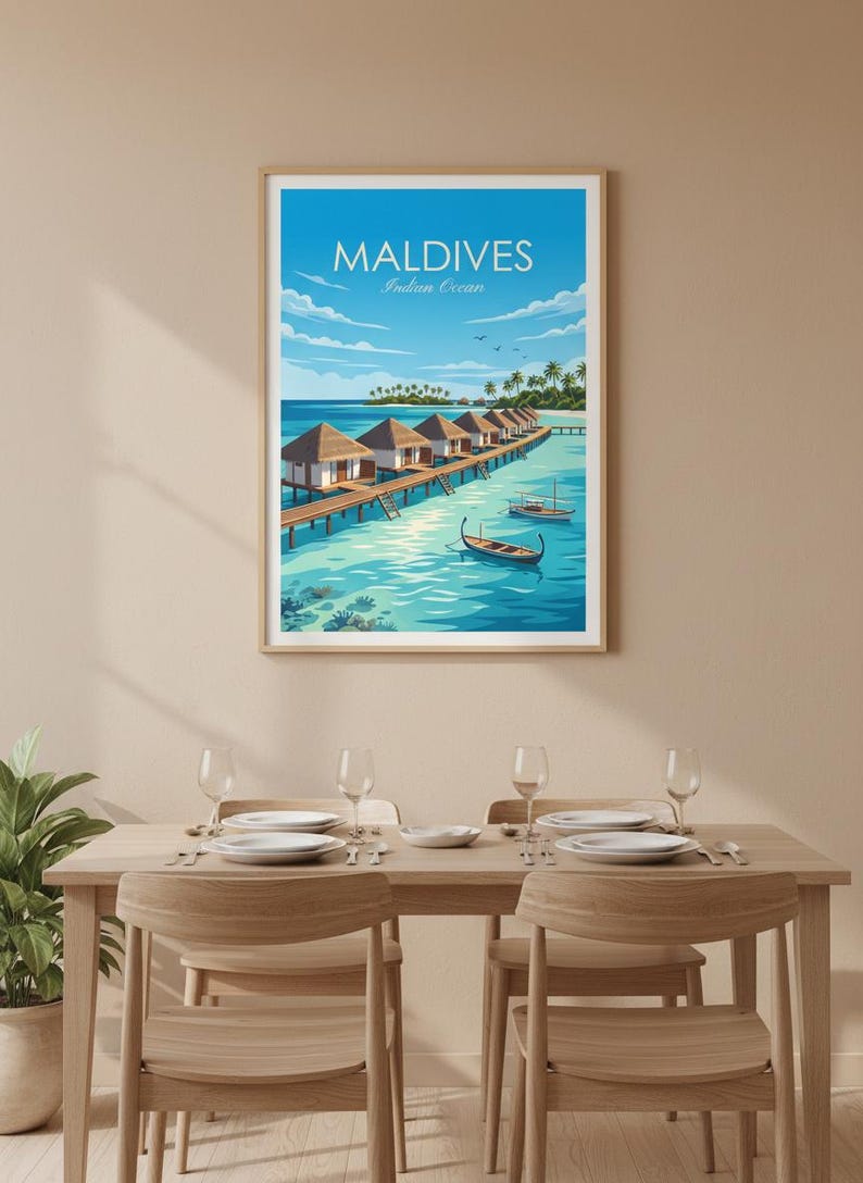 May include: A framed print of the Maldives, featuring overwater bungalows on a pier, turquoise water, and the text "Maldives Indian Ocean." The artwork is displayed above a dining table with place settings.