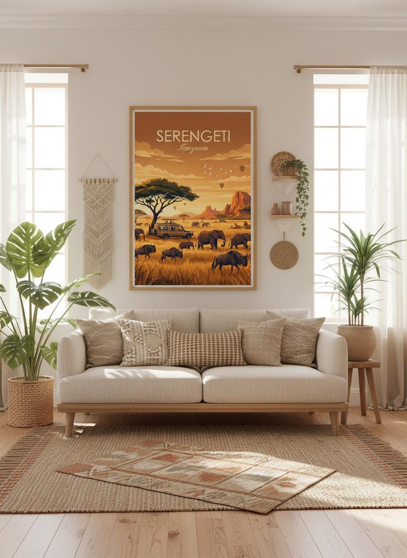 May include: A framed art print featuring a Serengeti landscape with elephants, a safari vehicle, and hot air balloons under a warm, golden sky. The print is displayed above a beige sofa with decorative pillows, creating a cozy living room scene.