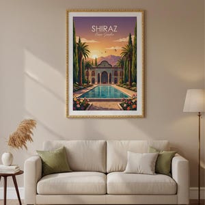 May include: Framed art print featuring a vibrant illustration of the Shiraz Eram Garden in Iran. The artwork depicts a serene pool, lush gardens, and a traditional building under a sunset sky. The print is in a gold frame and hangs above a beige sofa.