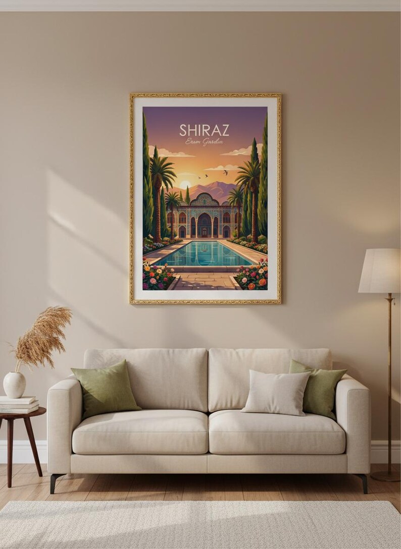 May include: Framed art print featuring a vibrant illustration of the Shiraz Eram Garden in Iran. The artwork depicts a serene pool, lush gardens, and a traditional building under a sunset sky. The print is in a gold frame and hangs above a beige sofa.
