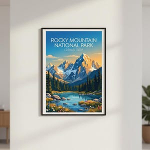 May include: A framed art print showcasing a landscape of the Rocky Mountain National Park in Colorado, USA. The image presents a mountain range, a lake, and evergreen trees under a blue sky. The text "Rocky Mountain National Park" is displayed at the top.