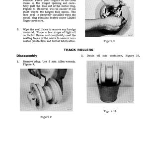 May include: Black and white technical manual page with instructions for track roller disassembly. Includes diagrams of hands using tools and components, with text and figure numbers.