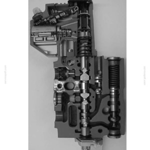 May include: A grayscale cross-section diagram of an EHS auxiliary control unit. The image shows the internal components of the unit, including springs, valves, and various mechanical parts. Text at the top reads "Cross-section of the EHS auxiliary control unit."