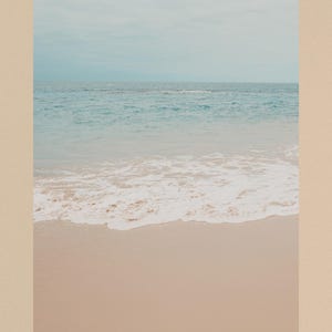 Puede incluir: Una serena escena de playa con un cielo azul claro que se encuentra con el oc&eacute;ano. La imagen captura las suaves olas rompiendo en la orilla arenosa. La paleta de colores es suave, con tonos de azul, blanco y beige, creando una est&eacute;tica costera relajante.