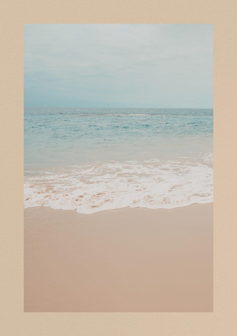 Puede incluir: Una serena escena de playa con un cielo azul claro que se encuentra con el oc&eacute;ano. La imagen captura las suaves olas rompiendo en la orilla arenosa. La paleta de colores es suave, con tonos de azul, blanco y beige, creando una est&eacute;tica costera relajante.
