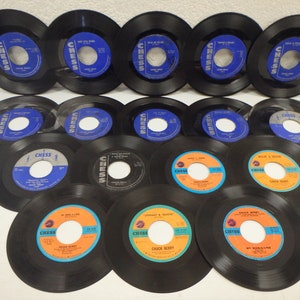 May include: A collection of 14 black vinyl 45 rpm records with colorful labels. The labels feature the word "CHESS" and the names of various artists, including Chuck Berry, Johnny &  Good, and  My Darling.