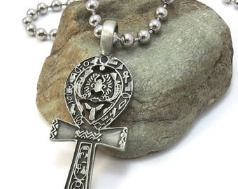 May include: Silver Ankh pendant necklace with intricate details and hieroglyphics. The pendant is on a silver ball chain.