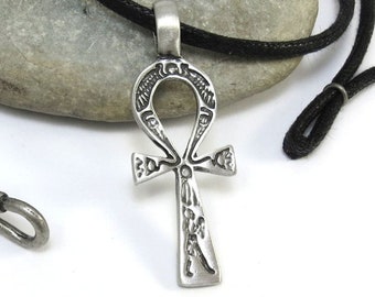 May include: A silver Ankh pendant necklace with intricate details, hanging on a black cord with a silver hook clasp.