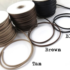 Pu&ograve; includere: Tre bobine di cordoncino in pelle di colore beige, marrone e nero. I cordoncini sono avvolti attorno a bobine di cartone bianco. I cordoncini sono etichettati "Tan", "Marrone" e "Nero".