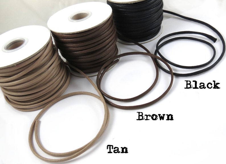 Pu&ograve; includere: Tre bobine di cordoncino in pelle di colore beige, marrone e nero. I cordoncini sono avvolti attorno a bobine di cartone bianco. I cordoncini sono etichettati "Tan", "Marrone" e "Nero".