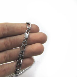 May include: A silver curb chain necklace with a lobster clasp.