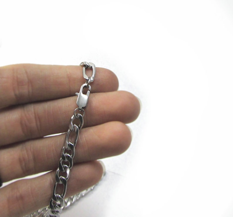 May include: A silver curb chain necklace with a lobster clasp.