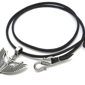 May include: A silver pendant necklace with a winged goddess design. The necklace is on a black cord with a silver clasp.