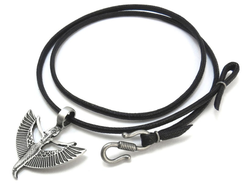 May include: A silver pendant necklace with a winged goddess design. The necklace is on a black cord with a silver clasp.