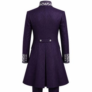May include: A long, deep purple coat featuring a high collar with intricate silver embroidery. The cuffs also display matching silver embroidery and four silver buttons. A horizontal back tab with two silver buttons sits above a central vent.