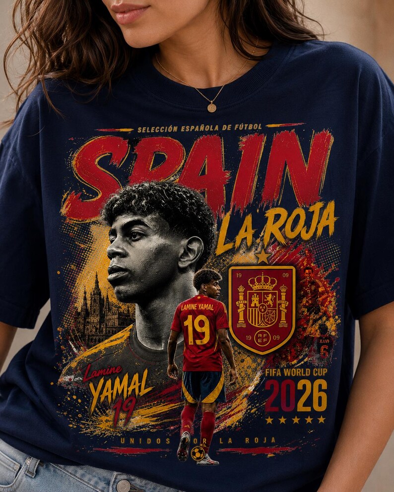 以下が含まれることがあります： サッカー選手ラミン・ヤマルがプリントされたネイビーブルーのTシャツ。デザインには「SPAIN」「LA ROJA」「Lamine YAMAL 19」「FIFA WORLD CUP 2026」の文字、スペイン代表チームのエンブレム、赤いユニフォームを着た選手の姿が描かれています。