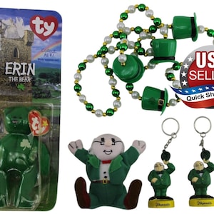 May include: A Ty Erin the Bear figurine in packaging, a string of green and white beads with miniature green top hats, a plush leprechaun doll, and two leprechaun keychains. The packaging features a castle and the text Erin the Bear.
