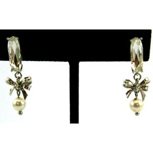 May include: A white ceramic mug with a black handle and the text "But First, Coffee" in a black, handwritten-style font. The mug is on a white surface.