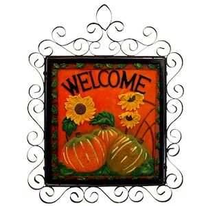 May include: A rectangular welcome sign with a black frame and decorative wrought iron scrollwork. The sign features an orange background with sunflowers and pumpkins. The word "WELCOME" is written across the top.