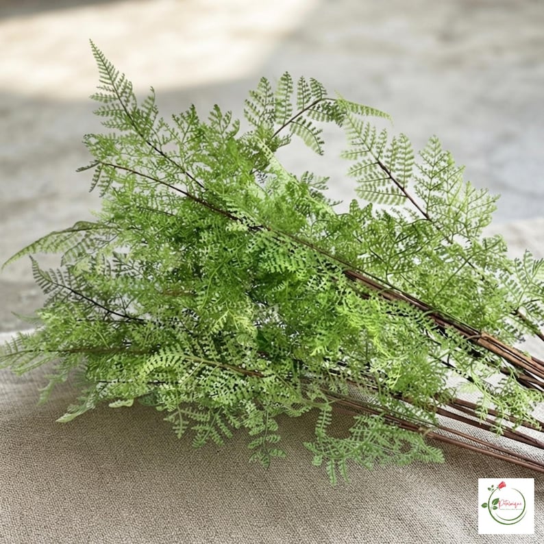Faux evergreen branch decorating a holiday table centerpiece