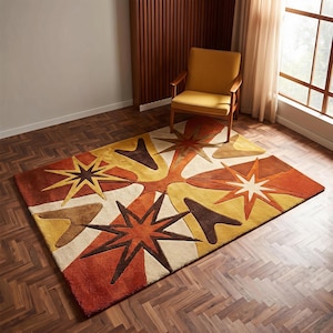 Könnte beinhalten: Ein rechteckiger Teppich mit einem geometrischen Muster aus mehrzackigen Sternen und Bumerang-Formen in den Farben gebranntes Orange, Senfgelb, Braun und Creme. Das Design ist symmetrisch mit überlappenden Formen und scharfen, kantigen Linien.