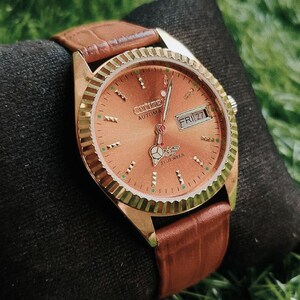 Relógio Citizen automático vintage com mostrador dourado, caixa de aço e indicador de dia/data.