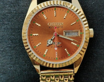 Relógio de pulso masculino Citizen automático, 21 rubis, banhado a ouro, mostrador laranja, dia/data, década de 1970.