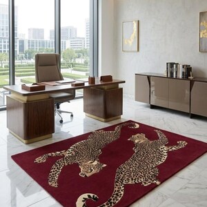 May include: A rectangular area rug featuring a deep burgundy background with two large, detailed leopard illustrations in shades of tan, brown, and black. The leopards are depicted in a dynamic, sprawling pose across the center of the rug.
