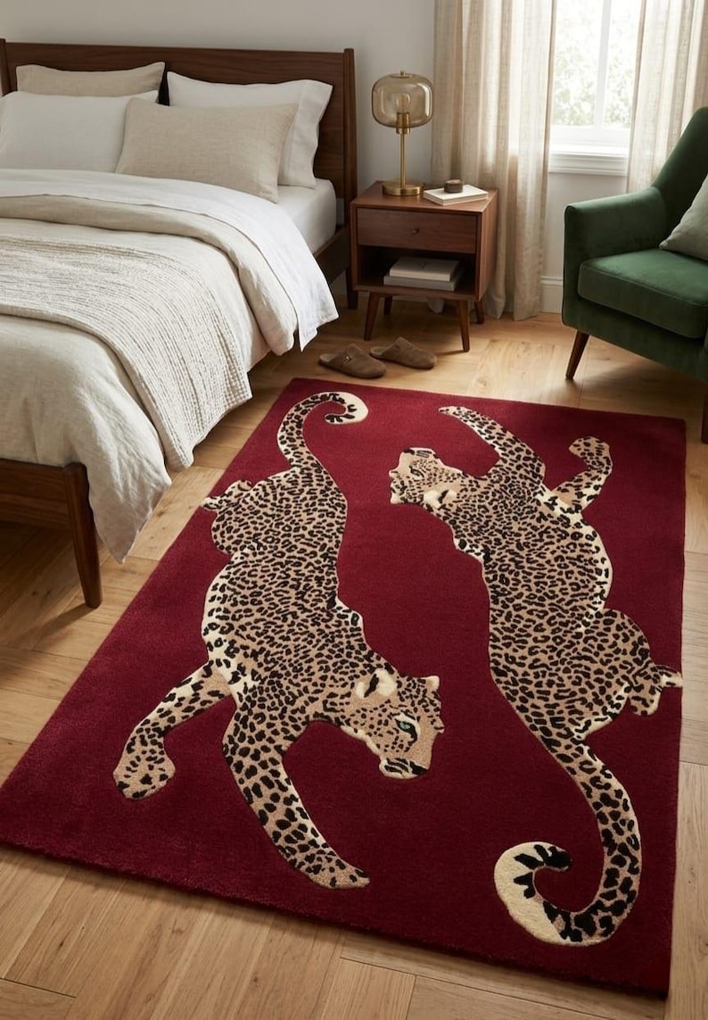 May include: A rectangular area rug in a deep burgundy red color featuring two large, detailed leopard figures with black and brown spots. The leopards are positioned in a mirrored, dynamic pose across the center of the rug surface.