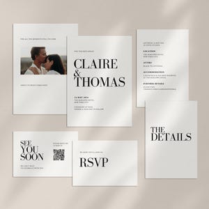 May include: A wedding stationery suite featuring white cards with black serif typography. The set includes an invitation for Claire & Thomas, a details card, an RSVP card, a photo card, and a See You Soon card with a QR code. The text provides event details including the date, location, and attire.