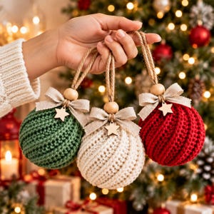 May include: Three spherical Christmas ornaments featuring a textured crochet knit pattern in green, cream, and red. Each ornament is topped with a beige fabric bow, a small wooden star charm, a natural wooden bead, and a jute twine hanging loop.