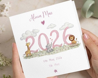 Puede incluir: Tarjeta blanca con el nombre "Alicia Mae" y el año "2026" en rosa, adornada con nubes, corazones e ilustraciones de animales. La tarjeta también incluye la fecha "5 de mayo de 2026" y el peso "7lb 13oz".