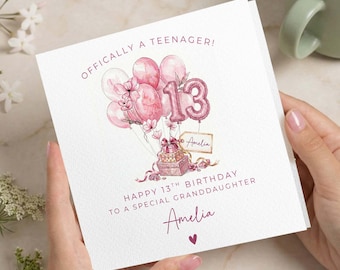 Peut inclure: Carte de vœux blanche avec des illustrations à l'aquarelle rose de ballons, d'un gâteau et du chiffre 13. La carte indique "Officiellement une adolescente ! Joyeux 13e anniversaire à une petite-fille spéciale" avec le nom "Amelia" et un cœur.