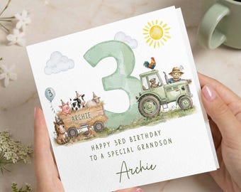 May include: A birthday card with a watercolor illustration of a green tractor, farm animals, and a large number 3. The card reads "Happy 3rd Birthday to a Special Grandson" and is personalized with the name "Archie".