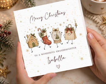 May include: A square white greeting card featuring the text Merry Christmas, TO A WONDERFUL GRANDDAUGHTER, and Isabella with a heart. The illustration shows a gingerbread house, a stocking, a snow globe, and a gift bag with faces.