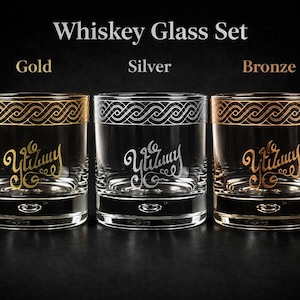 Peut inclure: Ensemble de trois verres à whisky avec des bordures dorées, argentées et bronze. Chaque verre présente un design unique et le mot "Yuzumy" dans une écriture stylisée. Fond noir.