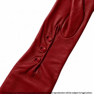Könnte beinhalten: Nahaufnahme von roten Lederhandschuhen. Die Handschuhe haben drei kleine, runde Knöpfe am Handgelenk. Das Leder wirkt glatt und die Farbe ist ein leuchtendes Rot.