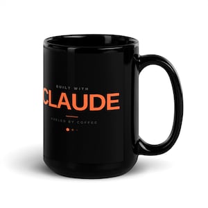 Puede incluir: Taza de café negra con el nombre "CLAUDE" en letras de bloque naranja. Los textos "BUILT WITH" y "FUELED BY COFFEE" están encima y debajo del nombre. La taza tiene un asa grande y un acabado brillante.