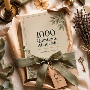 May include: A hardcover journal titled 1000 Questions About Me: A Guided Self-Discovery Journal, wrapped in brown paper with a sage green ribbon and a small tag reading for you you, accompanied by a candle, a wax seal stamp, and dried lavender.