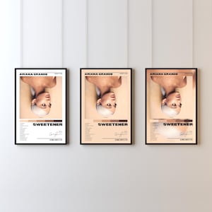 Puede incluir: Tres carteles enmarcados del álbum "Sweetener" de Ariana Grande. Cada cartel, en un marco negro, muestra un retrato de la cantante, el título del álbum, la lista de canciones y la firma. Los carteles están alineados.