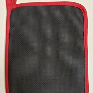 May include: A black heat-resistant pot holder with a red stitched border and a red loop handle.
