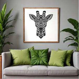 May include: A framed artwork depicting a black and white giraffe head with tribal patterns. The picture hangs above a grey sofa with green cushions. The room has a modern, nature-inspired aesthetic, with a focus on the artwork.